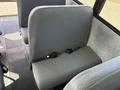 A 2011 Freightliner B2 bus seat with a gray upholstered backrest and a safety belt attached