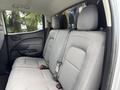 The image shows the interior of a 2018 Chevrolet Colorado featuring gray fabric seats in the rear row with two seatbelts visible