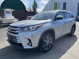 A silver 2018 Toyota Highlander parked with a sleek design featuring a prominent front grille and alloy wheels