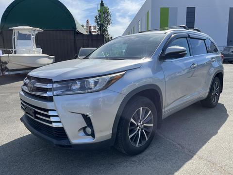 A silver 2018 Toyota Highlander parked with a sleek design featuring a prominent front grille and alloy wheels