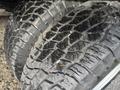 Close-up of two worn tires showing deep treads and some debris embedded in the rubber