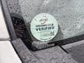 A circular odometer verification sticker affixed to the windshield of a 2008 Suzuki Carry displaying the text ODOMETER VERIFIED and a QR code