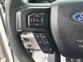 Close-up of the steering wheel controls of a 2017 Ford F-150 including buttons for setting cruise control and adjusting settings