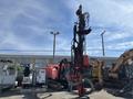 A 2018 Sandvik Ranger DX800 rock drill with a tall, red structure and various attached cables and hoses