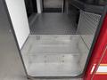 A metallic diamond plate step leading into a vehicle with red and white design elements visible in the foreground