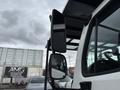 Close-up of a 2021 Freightliner M2 106 side mirror showing the reflective glass and its mounting on the cab with a view of the truck's window and interior