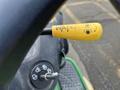 A close-up of a yellow control lever on a 2021 John Deere L Series S tractor featuring markings indicating water levels and operational functions