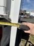 A person measuring the side of a 2018 Westland Travelaire with a tape measure