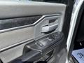 Interior door panel of a 2020 Ram 2500 featuring a window control switch and a metallic door handle