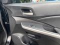 Interior door panel of a 2014 Honda CR-V featuring controls for power windows and locks with a sleek design and ergonomic handle