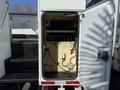 Open door revealing the interior of a compartment in a 2008 International 7500 with shelving and electrical components visible inside