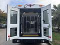 A 2021 Ford Transit-350 with double rear doors open revealing a wheelchair lift and spacious interior designed for transportation of individuals with mobility needs