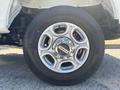 A close-up of a 2023 Ford F-350 SD wheel featuring a silver alloy rim with six spokes and a chrome center cap with the Ford logo