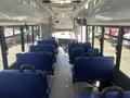 Interior view of a 2020 Chevrolet Express showing blue seats arranged in rows with a driver's area visible at the front