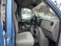 Interior of a 2009 Ford Econoline showing the driver's seat dashboard and middle console with cup holders
