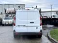 A 2017 Ford Transit Connect van is parked facing forward with a roof rack visible on top and a plain white exterior
