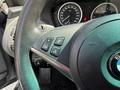 Close-up of the steering wheel of a 2004 BMW 6-Series featuring controls for phone and audio functions with the BMW logo prominently displayed