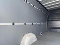 Interior view of a 2024 Mercedes-Benz Sprinter van showing a gray wall with storage straps and a smooth floor