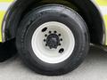 Close-up of a white wheel and tire of a 1995 Freightliner FL086 with black Michelin radial tire and a five-bolt hub assembly