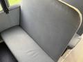 A gray vinyl seat with a padded backrest in a vehicle interior designed for passenger seating