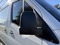 Close-up of the side mirror of a 2023 Mercedes-Benz Sprinter 2500 showing a sleek design with a black housing and clear glass surface