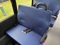 Interior view of a blue upholstered seat in a 2020 Chevrolet Express with seatbelts attached