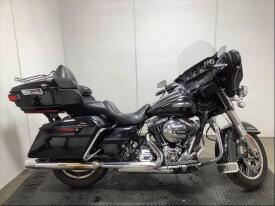 A black 2016 Harley-Davidson FLHTCU motorcycle featuring a tall windshield comfortable seating and chrome accents