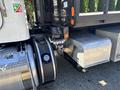 Close-up of a 2020 Peterbilt 330 truck showcasing the rear axle and fuel tank with visible connections and a silver panel
