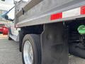 A 2013 RAM 5500 with a large flatbed and prominent wheel well showing a 'Work Truck' emblem on the fender
