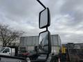 A close-up view of the side mirrors of a 2022 Freightliner B2 showing two mirrors mounted on a black frame
