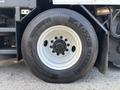 A wheel of a 2012 International DuraStar 4300 truck featuring a black tire with visible tread and a white rim showcasing multiple lug nuts