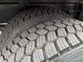 Close-up of two tires from a 2016 Peterbilt 348 showcasing a rugged tread pattern designed for enhanced traction and durability