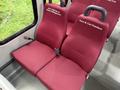 Red upholstered seats with seatbelts in a van labeled with the names Jerry Wehrn and Sean Hollingsworth and Kent and Cari Davidson
