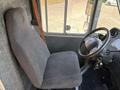 Interior view of a 2012 Ford Econoline showing the driver's seat and steering wheel with keys hanging from the ignition