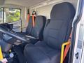 Two black upholstered seats in a vehicle's cabin, featuring orange seatbelts and a steering wheel, designed for comfort and safety