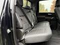 The interior of a 2022 GMC Sierra 3500HD showing the back seat with leather upholstery and seat belts