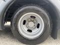 Close-up of a silver wheel and tire from a 2020 Chevrolet Express featuring a rugged tire tread pattern and a distinctive rim design