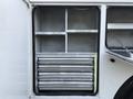 A 2013 International Durastar 4300 with an open storage compartment featuring shelves and metal drawers for organization