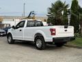 A white 2018 Ford F-150 parked with a rear view showing its bed and tailgate designed for utility and rugged use