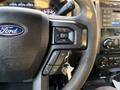 The steering wheel of a 2018 Ford F-350 SD featuring audio control buttons and keys attached to a keychain