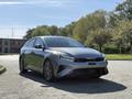 A gray 2024 Kia Forte5 parked at an angle showcasing its sporty design and sleek front grille with distinctive LED headlights and stylish alloy wheels