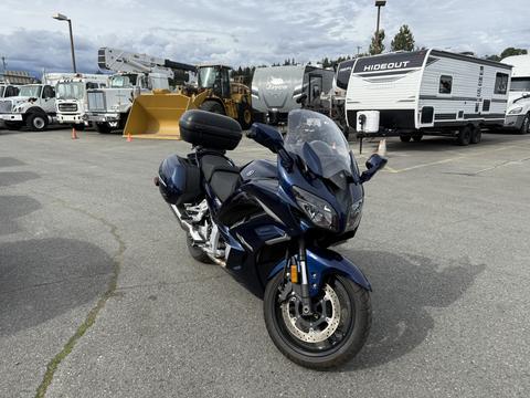 A 2016 Yamaha FJR1300AE motorcycle in blue with a windscreen and saddlebags positioned at an angle on a paved surface