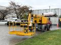 A yellow 2020 Haulotte HA61 LE PRO boom lift is positioned with its extended arm and work platform lowered on the ground