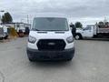 A 2024 Ford Transit van with a white exterior and a black front grille is pictured from the front view