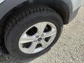 Close-up of a silver 2014 Ford Escape alloy wheel with a black tire showing a detailed tread pattern and a visible Ford logo on the rim