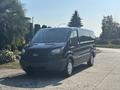 A black 2016 Ford Transit 150 van parked with a sliding side door and front grille prominently displayed