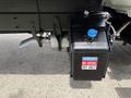 A black DEF tank attached to the side of a vehicle with a blue cap and a label reading NO DIESEL DEF ONLY