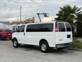 A white 2004 Chevrolet Express van parked with tinted windows and chrome wheels