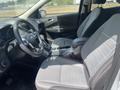 Interior of a 2015 Ford Escape featuring gray cloth seats and a black leather-wrapped steering wheel with various controls and a central console