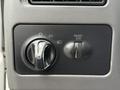 Control panel of a 2000 Ford F-450 featuring the headlight switch and panel dimmer knob